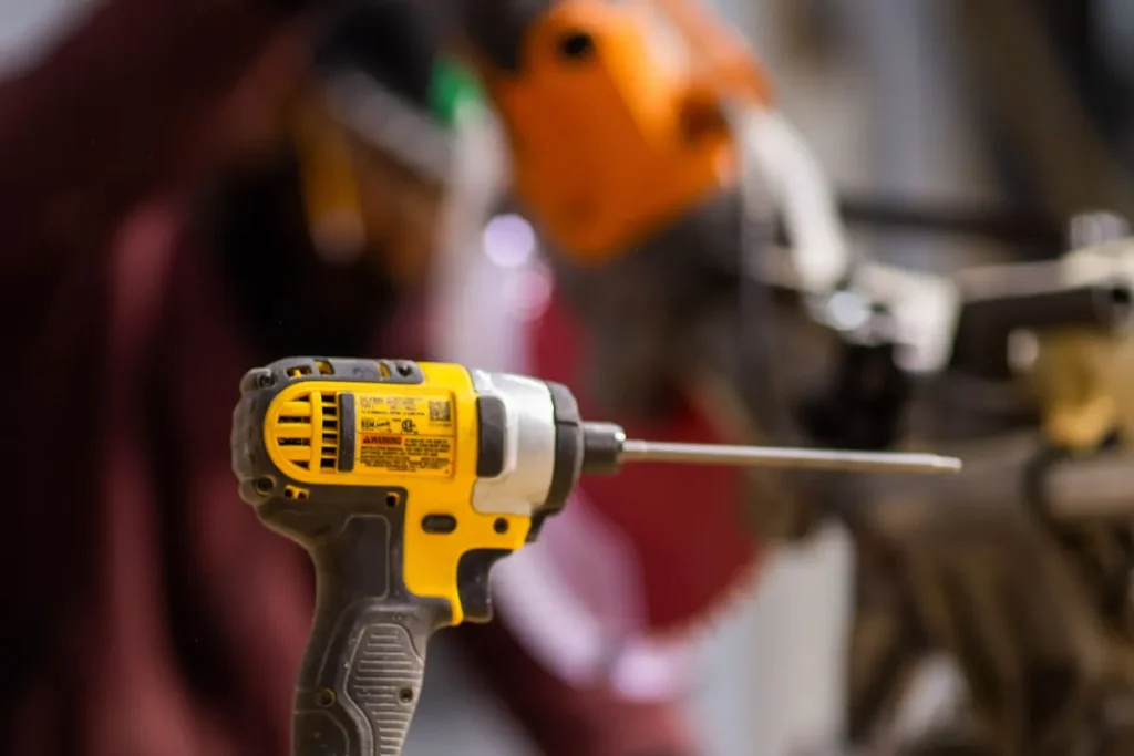 Cordless drill on a workbench for garage door opener repair