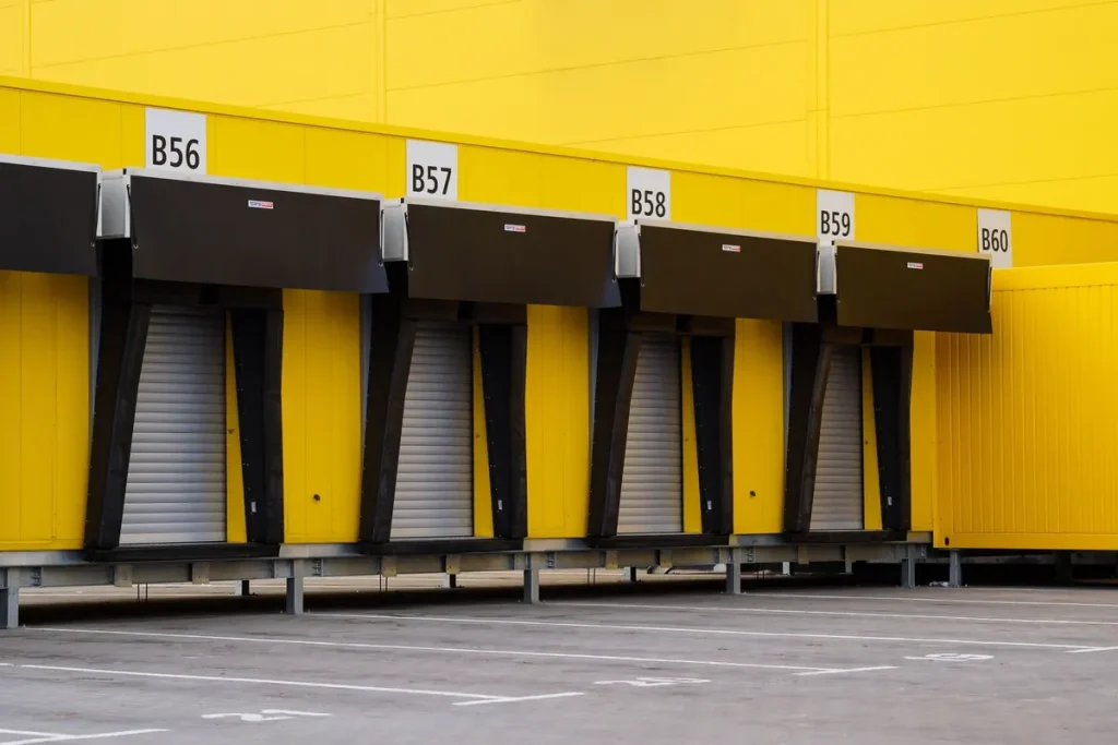 Row of loading dock doors on a yellow warehouse, commercial door service