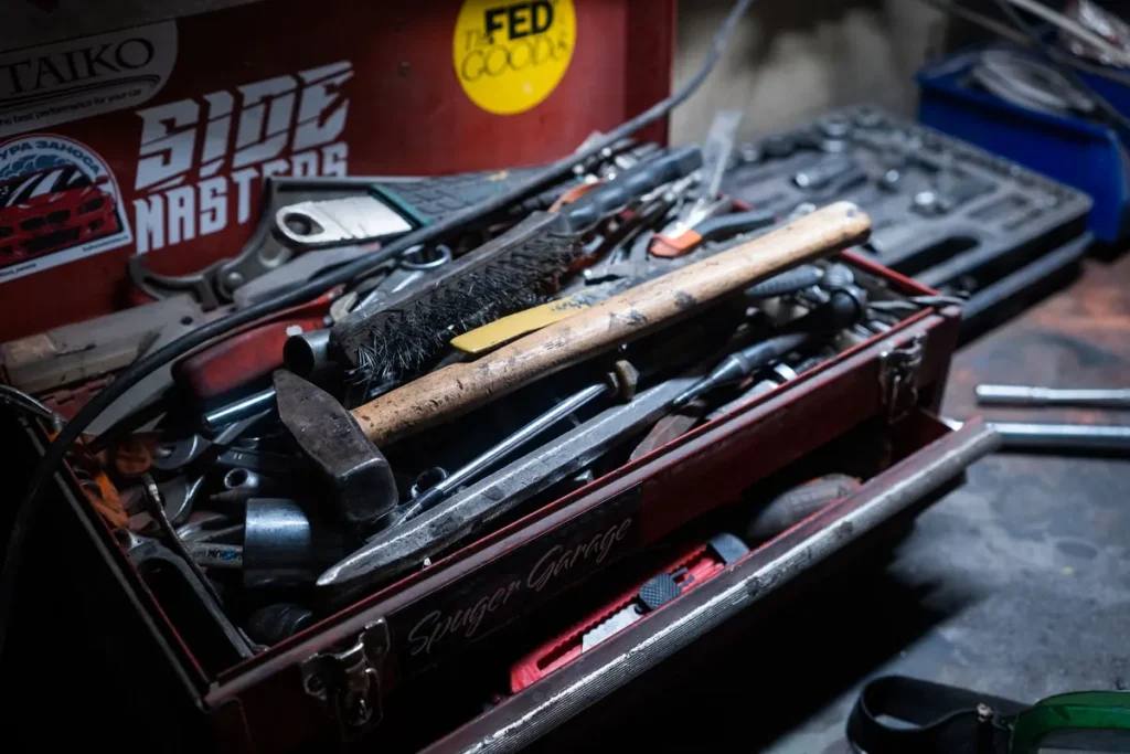 Open technician toolbox with hand tools for garage door cable repair