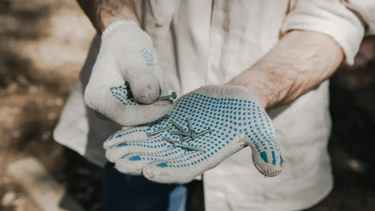 Gloved hands holding hardware during a garage door tune-up